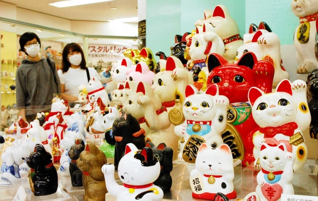 さまざまな表情をした招き猫の貯金箱が展示される会場＝尼崎信用金庫世界の貯金箱博物館