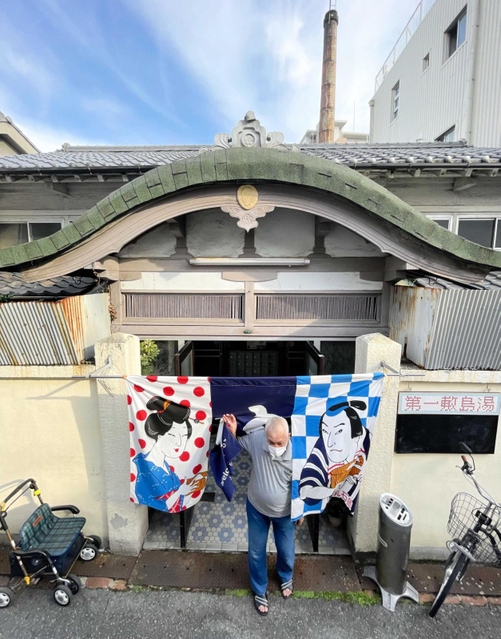 開業当初から残る唐破風屋根。奥には高さ２５メートルの煙突がのぞく＝第一敷島湯