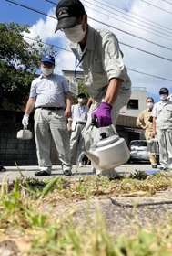 草に熱湯をかけ、枯死させる実験を披露する県職員＝西宮市津田町