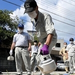 草に熱湯をかけ、枯死させる実験を披露する県職員＝西宮市津田町