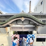 開業当初から残る唐破風屋根。奥には高さ２５メートルの煙突がのぞく＝第一敷島湯