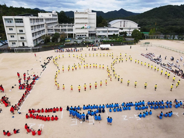 体育祭の伝統種目「ブロック演技」。色とりどりの人の列が「○」や「△」を描いた＝猪名川高校