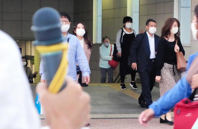 駅前でマイクを握り、通行人に支持を訴える衆院選の立候補予定者＝西宮市内