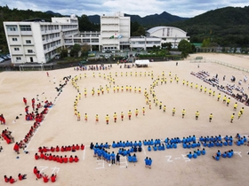 体育祭の伝統種目「ブロック演技」。色とりどりの人の列が「○」や「△」を描いた＝猪名川高校