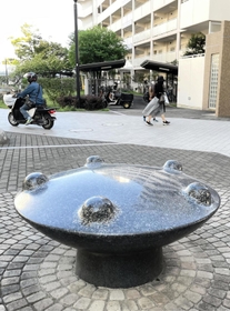 集合住宅の玄関付近に置かれた福嶋敬恭さんの作品「この美しい星の庭」＝西宮市西宮浜４