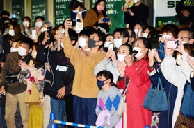 街頭演説会を聴く人たち。スマートフォンで撮影する若者の姿も＝阪急宝塚駅前