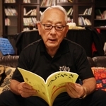 ３５年で重ねた冊子は約１００。冊子を手に取る松本理事長＝西宮市内