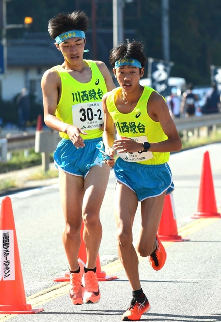男子・川西緑台の２区山尾知慶選手（左）からたすきを受け取る３区平井蒼大主将＝丹波篠山市内（撮影・坂井萌香）