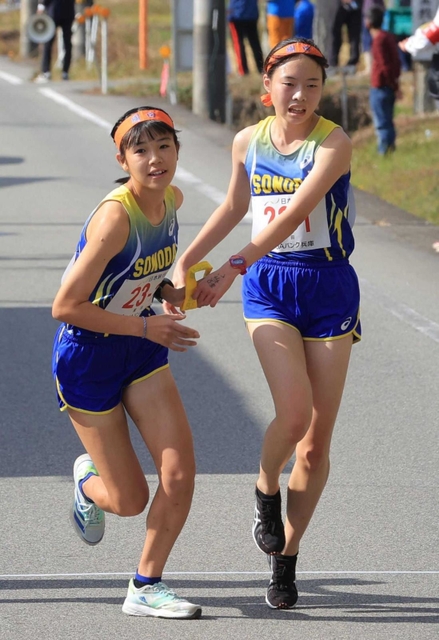 女子・園田の１区後田乃愛選手（右）からたすきを受け取る２区行安亜芽莉選手（撮影・吉田敦史）＝丹波篠山市内