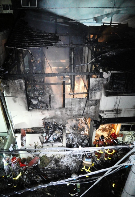 火元の長屋に放水する消防隊員＝１４日午後、尼崎市昭和通１（撮影・大田将之）