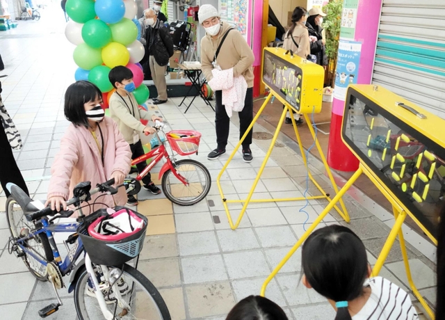 １００分の１秒まで表示できる本格的なタイマーで自分たちの記録を確かめた＝尼崎市建家町、三和本通商店街