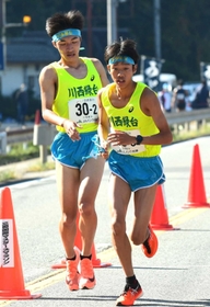 男子・川西緑台の２区山尾知慶選手（左）からたすきを受け取る３区平井蒼大主将＝丹波篠山市内（撮影・坂井萌香）