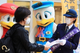 啓発グッズを手渡す警察官＝尼崎市潮江１