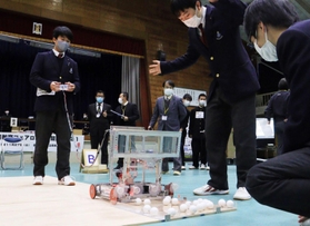 「リモコン式ロボット競技」で、声を掛け合いながら慎重に操作する生徒ら＝県立尼崎工業高校