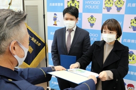 横田誠治署長からのじぎく賞を受け取る武原さん夫婦＝甲子園署