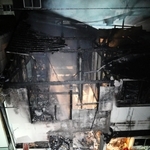 火元の長屋に放水する消防隊員＝１４日午後、尼崎市昭和通１（撮影・大田将之）