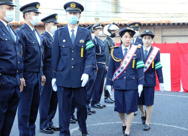 年末の交通事故防止運動発隊式で、署員の服装を点検する荒井選手（左）と杉原選手（右）＝甲子園署