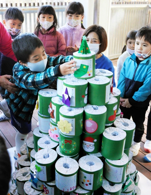 トイレットペーパーを積み上げてクリスマスツリーを完成させた園児ら＝いるか幼稚園