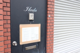 解体が始まる真鍋組事務所の玄関。「Ｉｋｅｄａ」の文字と公示書が貼られている＝尼崎市戸ノ内町３