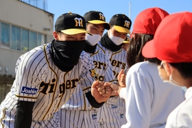 終了後に児童たちとグータッチする佐藤輝明選手（左）ら＝西宮市立用海小学校