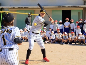 阪神タイガースの選手がゲストティーチャーとなった特別授業で、バッティングを披露する佐藤輝明選手＝西宮市立用海小学校