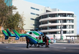 消防防災広場に着陸したヘリコプターから要救助者を降ろし、救急隊に引き継ぐ隊員＝猪名川町差組