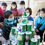 トイレットペーパーを積み上げてクリスマスツリーを完成させた園児ら＝いるか幼稚園