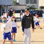 遠くへボールを投げる児童と見守る石井大智選手＝西宮市立用海小学校