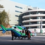 消防防災広場に着陸したヘリコプターから要救助者を降ろし、救急隊に引き継ぐ隊員＝猪名川町差組