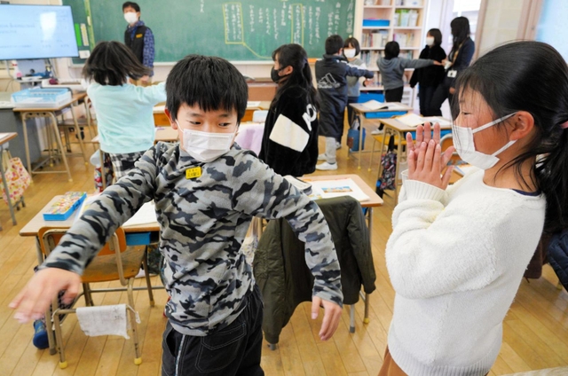 クラスメートとペアを組み「リラックス動作法」に取り組む児童ら＝花里小学校