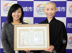 稲村和美市長（左）から「尼崎市文化未来奨励賞」を受けた露の団姫さん＝尼崎市役所