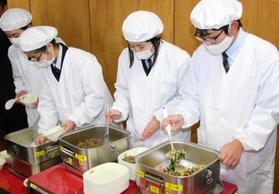 真新しい給食衣を着て盛り付けをする当番の生徒たち＝成良中学校