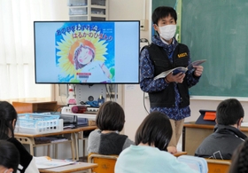 「南三陸にさく『はるかのひまわり』」を読み上げる投石悠一教諭＝花里小学校