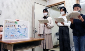 放送室で紙芝居を読む児童＝高木小学校