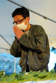 今年も芳名帳に名前を書き、手を合わせる大泉淳さん＝１７日午前、芦屋市浜芦屋町、芦屋公園