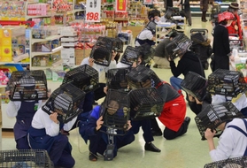 シェイクアウトの訓練で買い物かごをかぶる客や店員ら＝西宮市小松北町１、コープ西宮東