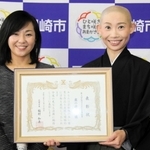 稲村和美市長（左）から「尼崎市文化未来奨励賞」を受けた露の団姫さん＝尼崎市役所