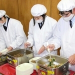 真新しい給食衣を着て盛り付けをする当番の生徒たち＝成良中学校