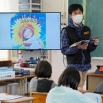 「南三陸にさく『はるかのひまわり』」を読み上げる投石悠一教諭＝花里小学校