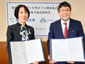 協定書を手にする尼崎ホテル開発の大矢悦子社長（左）と関西国際大の濱名篤学長＝関西国際大尼崎キャンパス