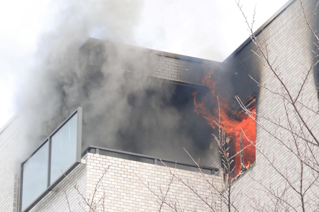 窓やベランダから黒煙と炎を上げるマンションの一室＝３月２日午前、芦屋市翠ケ丘町