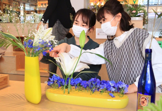 ウクライナをテーマにした生け花を手入れする石原千晶さん（左）と内良彩楓さん＝神戸市北区藤原台中町１、市立北神図書館
