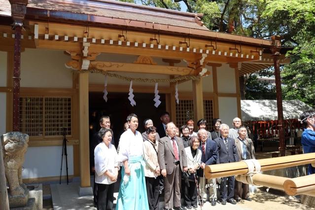 再建された拝殿前で記念撮影する神社関係者＝大市八幡神社