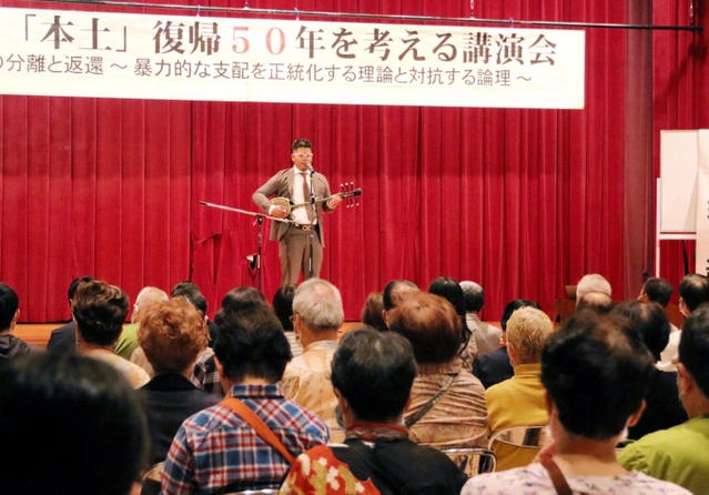 平和の願いを込めて、三線で弾き語りする渡久地翔さん＝尼崎市西御園町、尼崎市中央南生涯学習プラザ