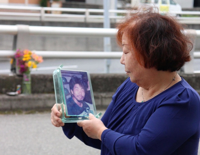 事件発生現場で、秋雄さんの遺影を見つめる母の盛山時枝さん＝川西市栄根２