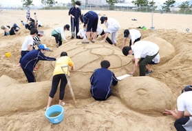 巨大な亀を作る高校生たち＝芦屋市南浜町、潮芦屋ビーチ
