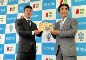 石井登志郎市長（右）から応援メッセージ入り絵馬を贈られた亀田和毅選手＝西宮市役所