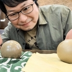 「自分史上最高レベル」の輝きを放つ泥団子（左）と２番手の泥団子を見つめる小林哲朗さん＝尼崎市内