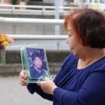 事件発生現場で、秋雄さんの遺影を見つめる母の盛山時枝さん＝川西市栄根２