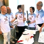 １９６４年と昨年の五輪トーチを見比べるランナーら。笑みが絶えない＝芦屋市大原町、ホテル竹園芦屋